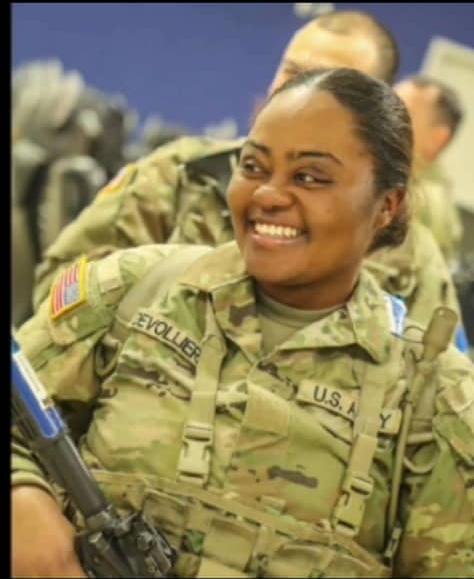 Gloria smiling in uniform with fellow soldiers
